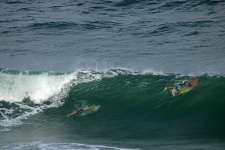 Surfers Going Under A Swell
