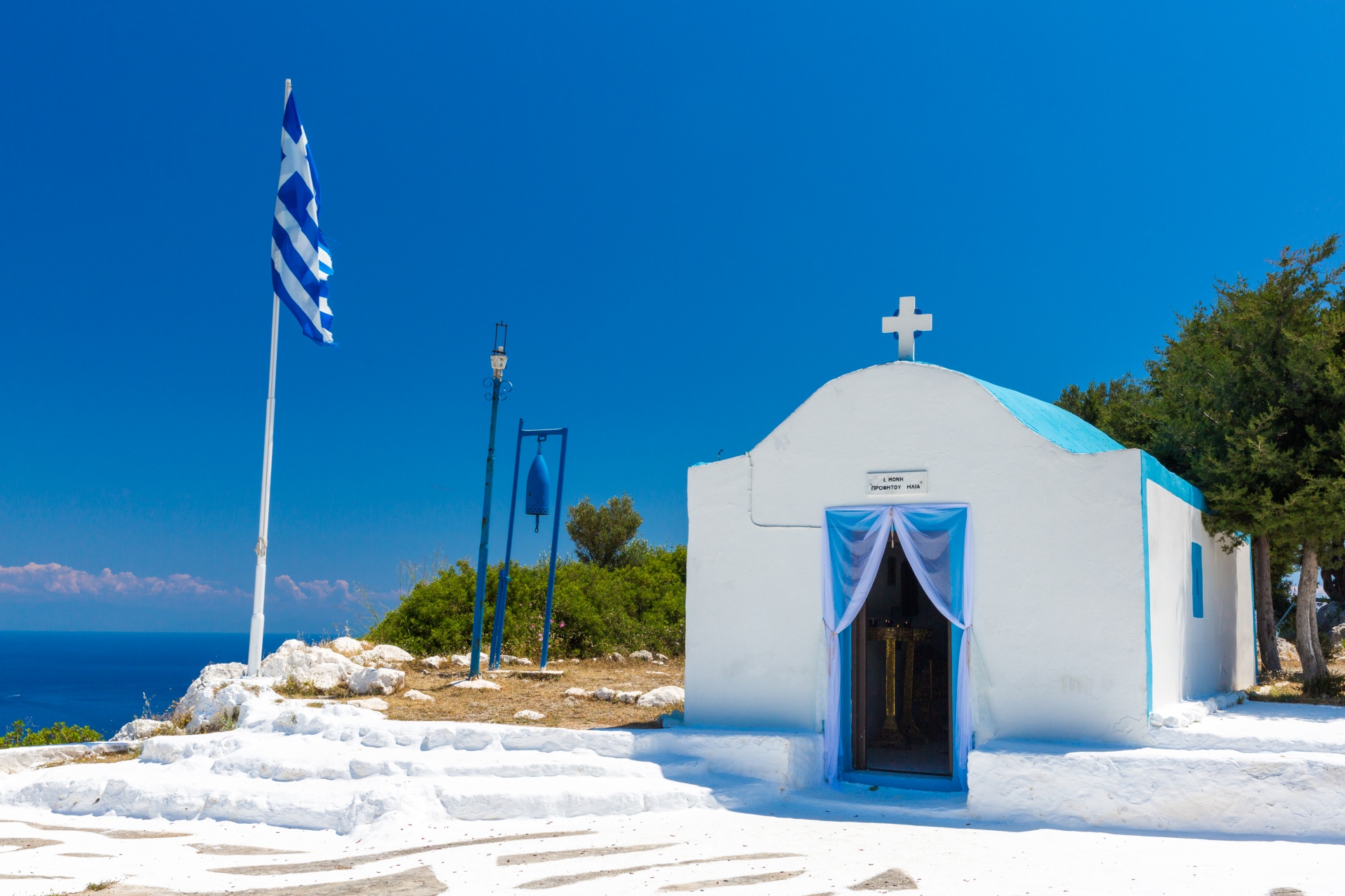 Greek church with a flag and a blue bell