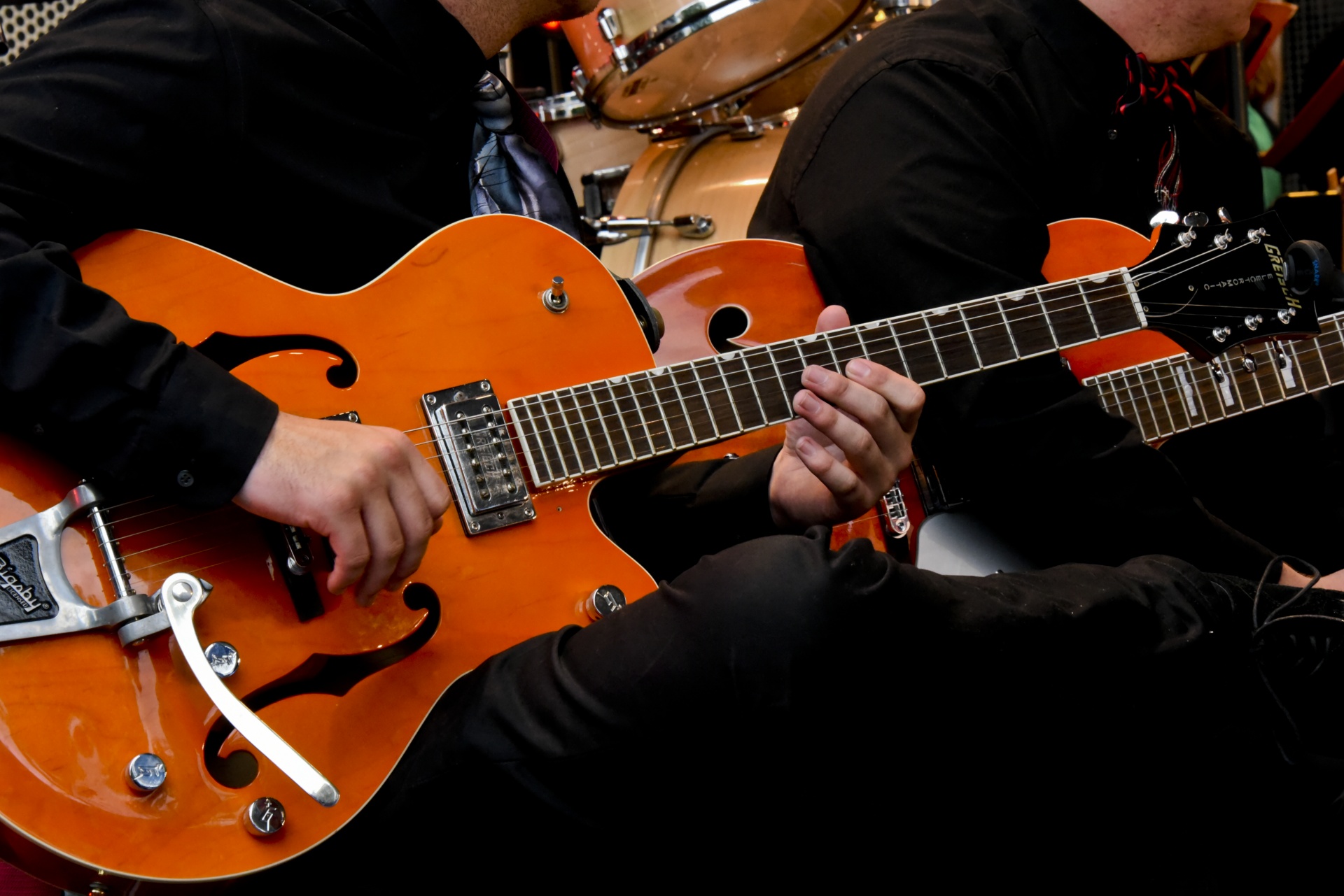 Young man playing a orange Gibson guitar