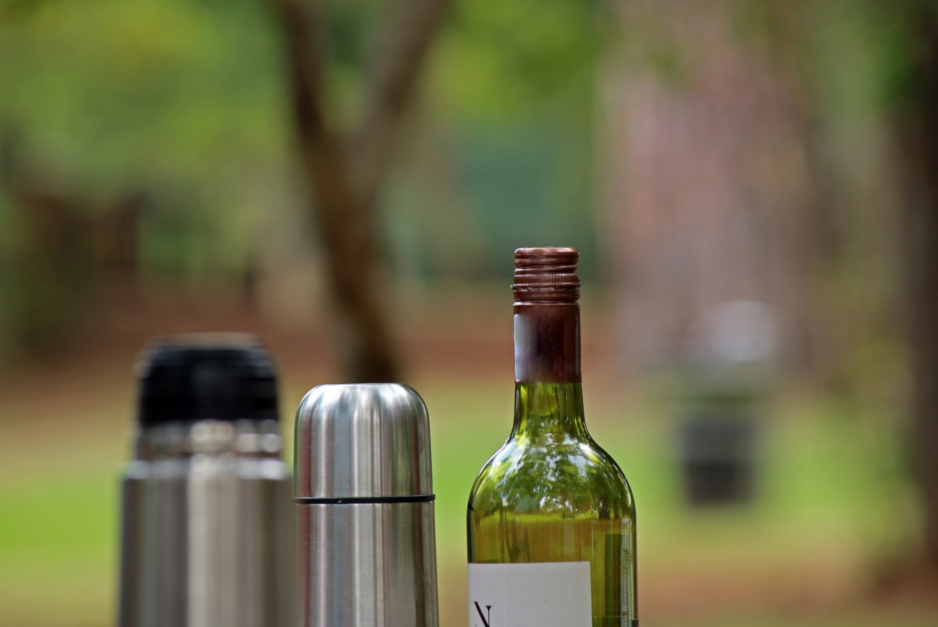 wine bottle and hot water flask in the outdoors