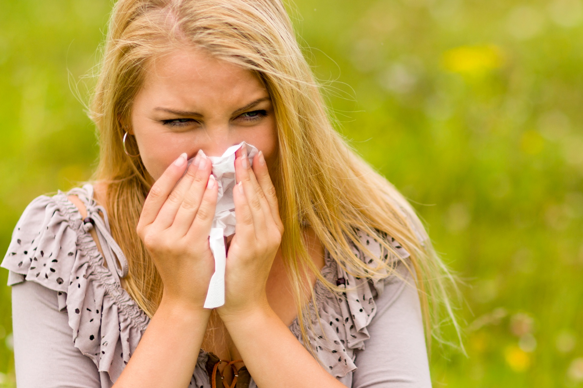 Young woman with a hay fever holding a tissue