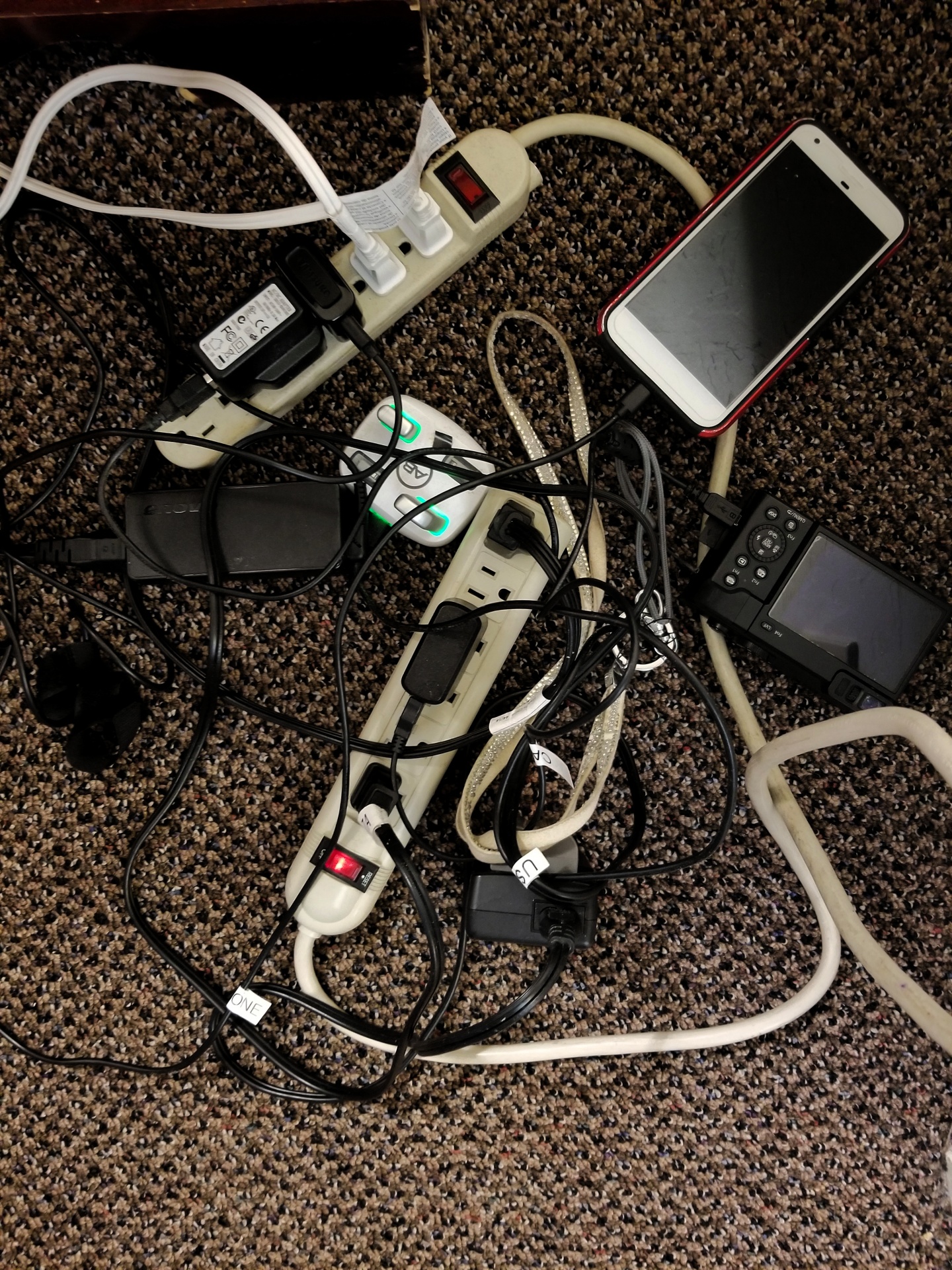 Looking down on the multiple electronic items plugged in for charging