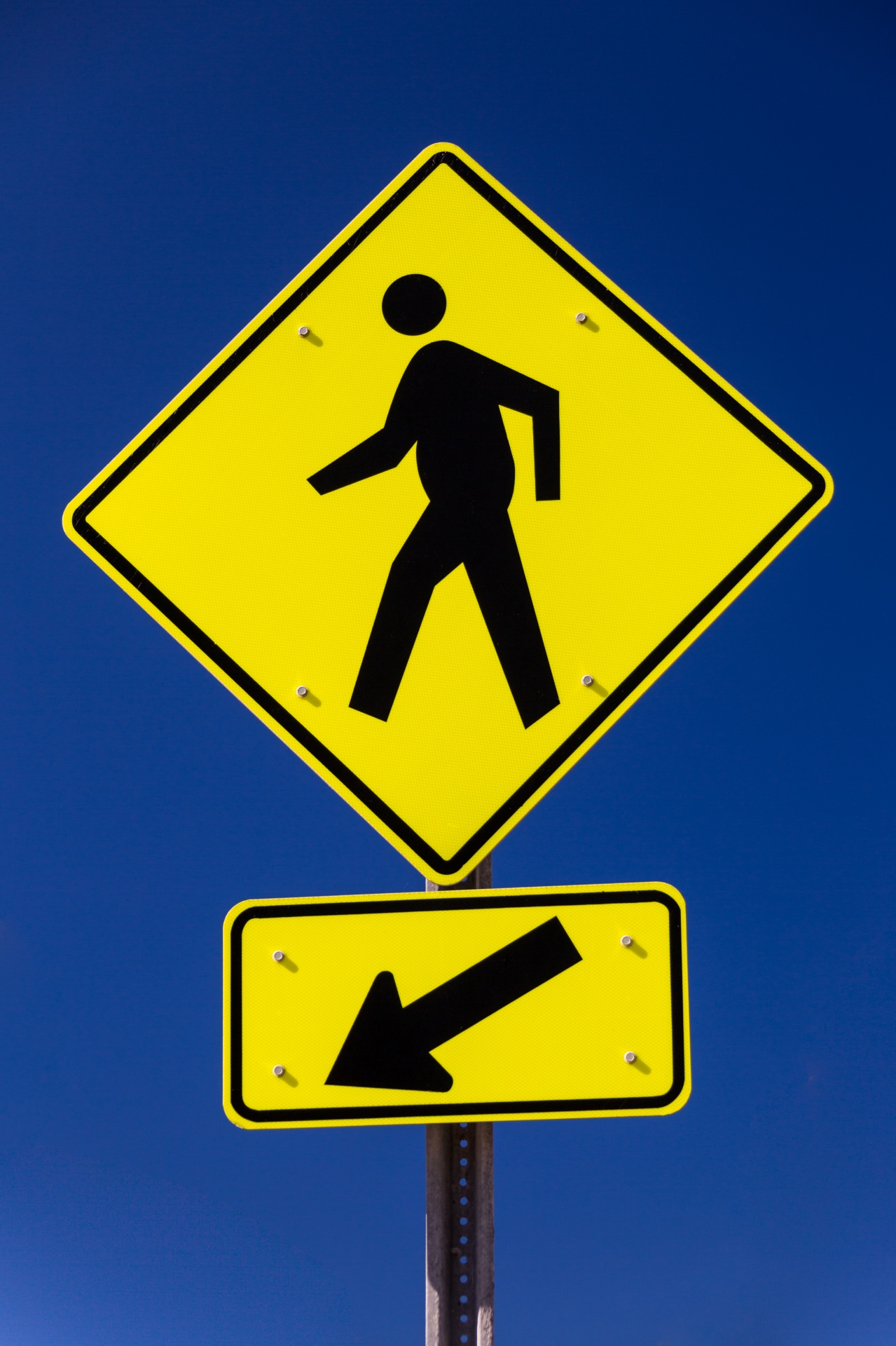 Pedestrian crossing sign against blue sky