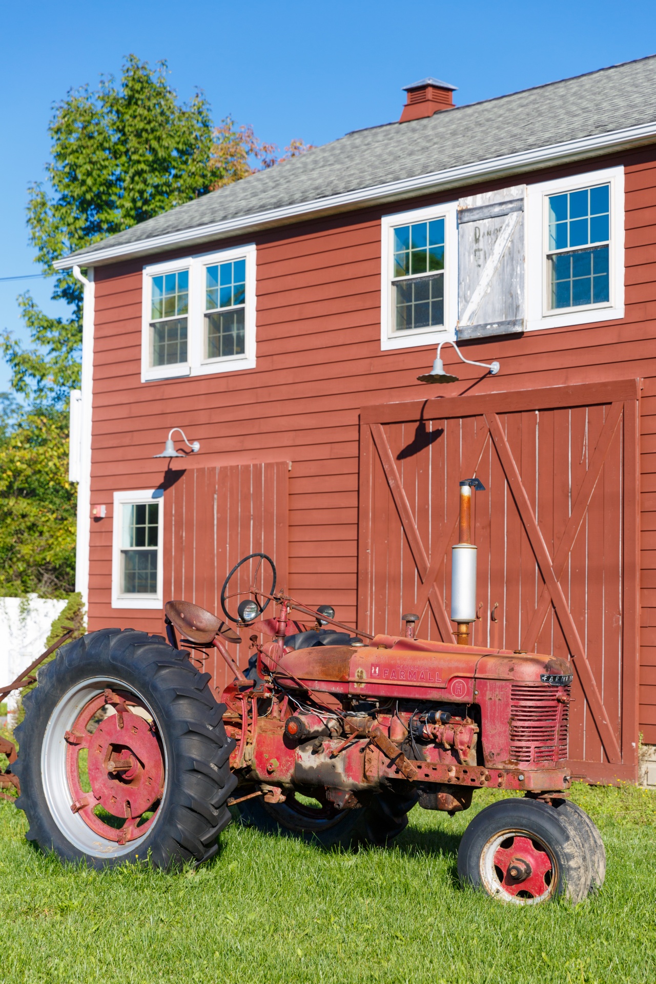 Red old tractor in front of a farm building