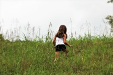 Little Girl Climbing Grassy Hill