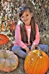 Little Girl On Hay With Pumpkins