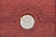 Old Round Window On Red Brick