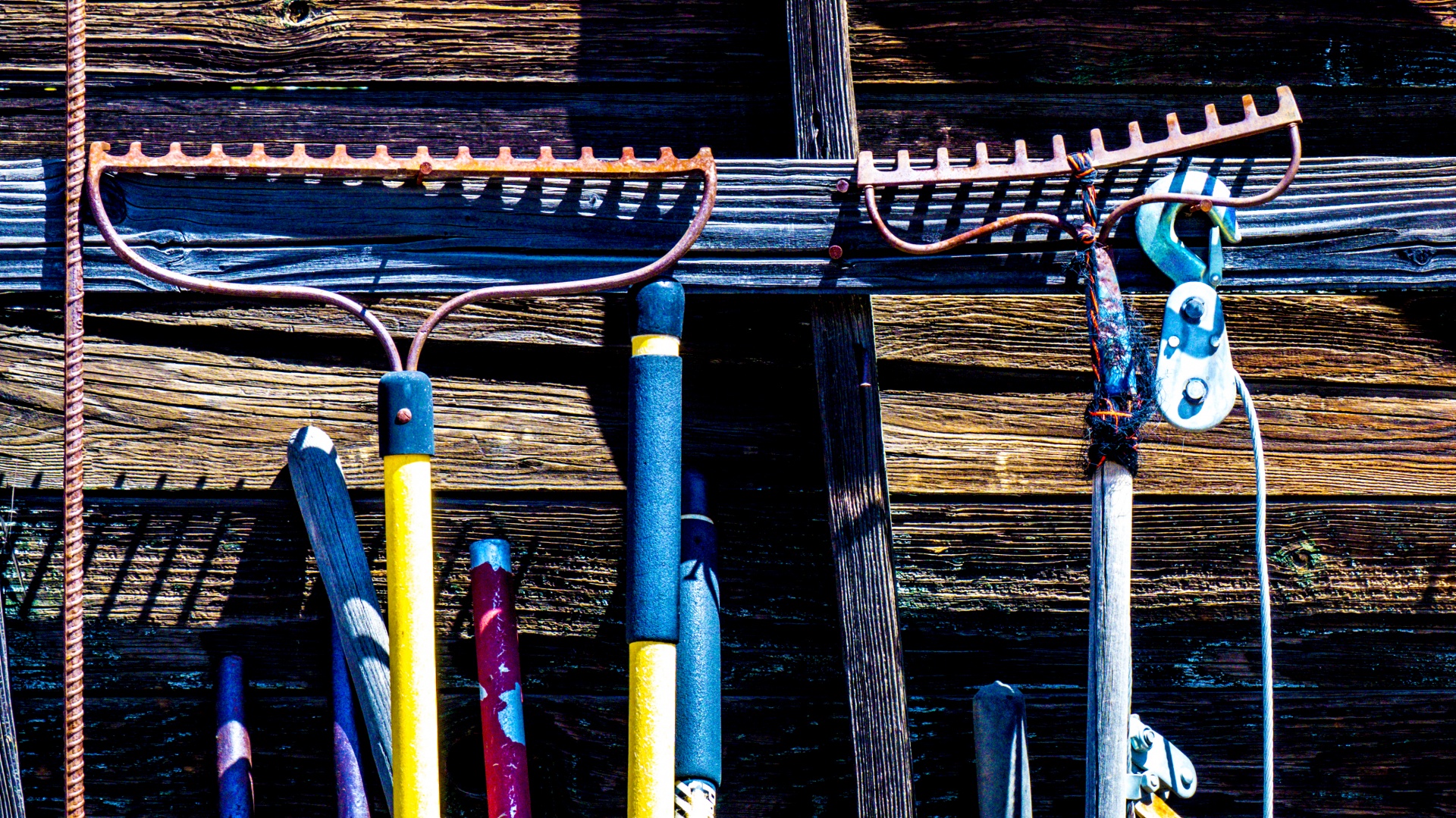 Rusty garden tools hanging on a shed