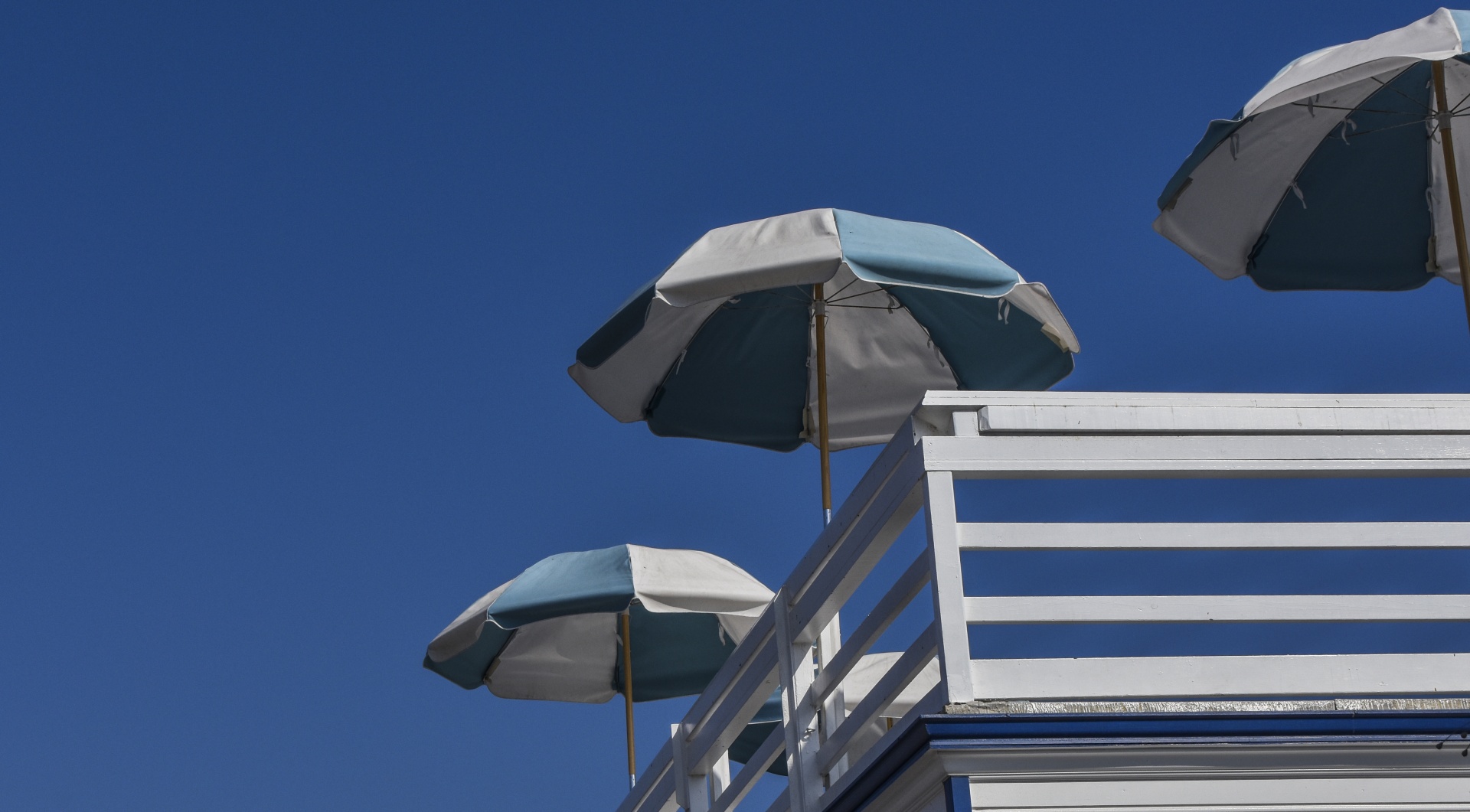 blue and white beach umbrellas on a pier