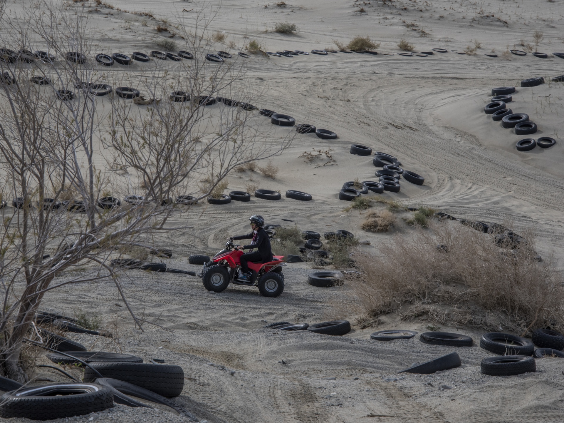 Quad cycle rider runs over a desert track in the sand
