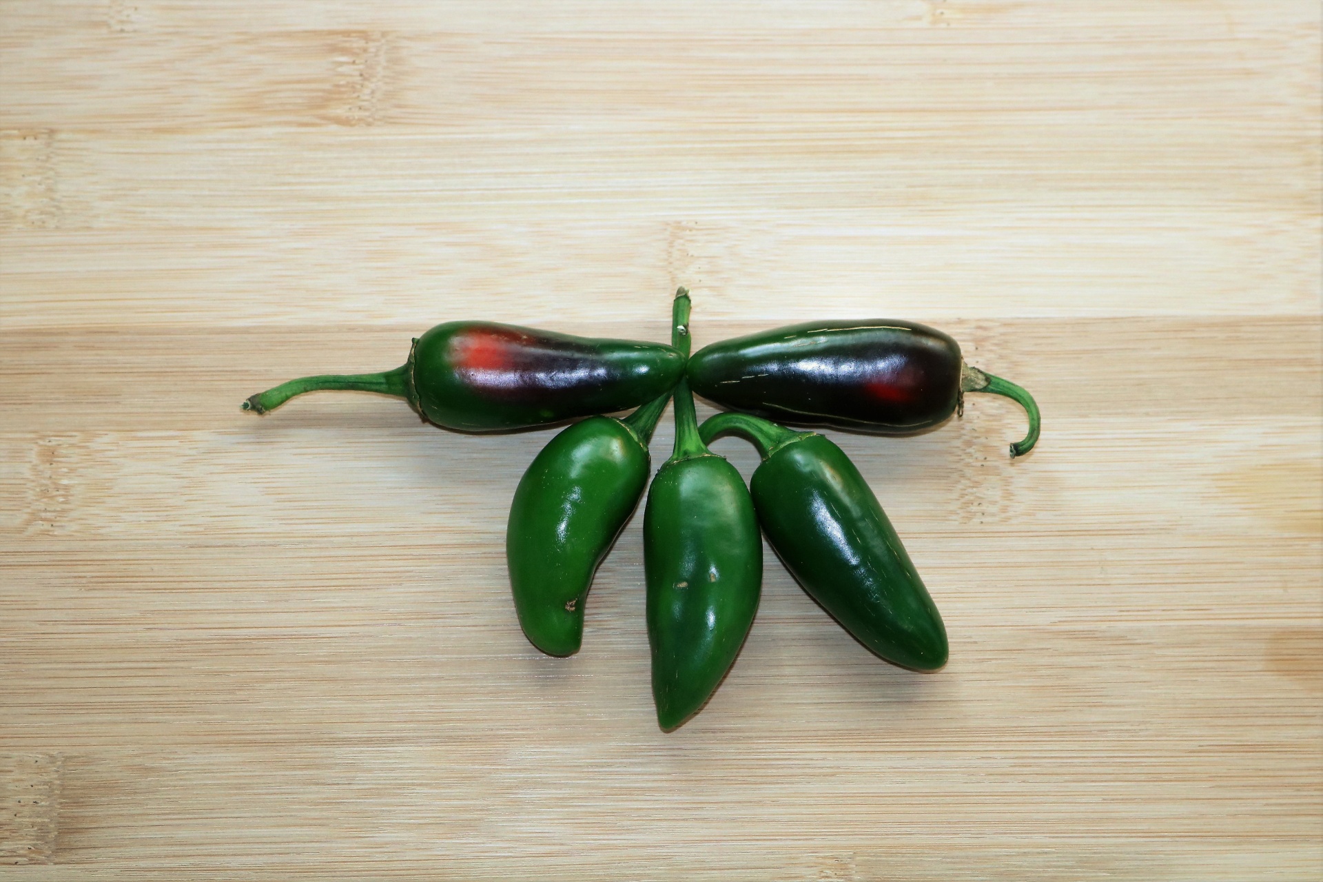 Five Jalapenos On Cutting Board