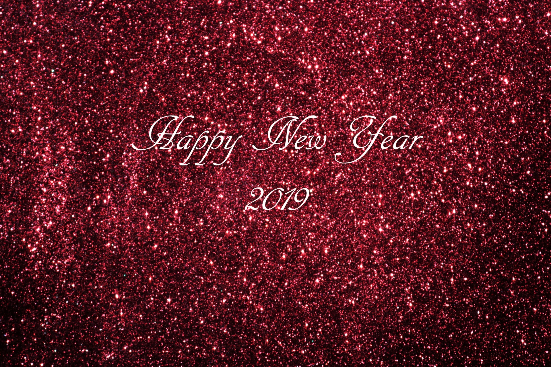 A sparkling burgundy glitter background with Happy New Year 2019 text in silver.