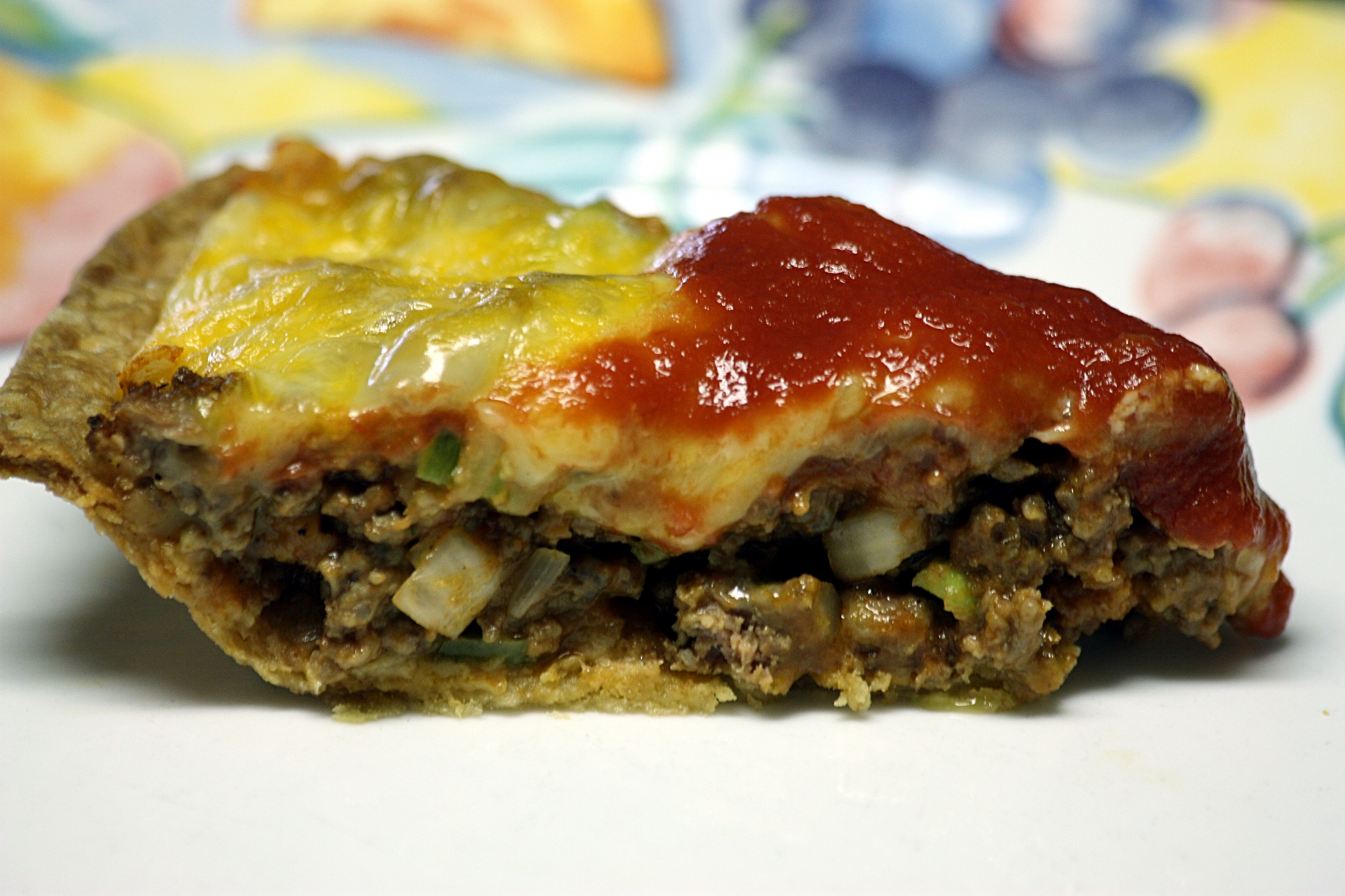 Close-up of a slice of cheeseburger pie on a plate.