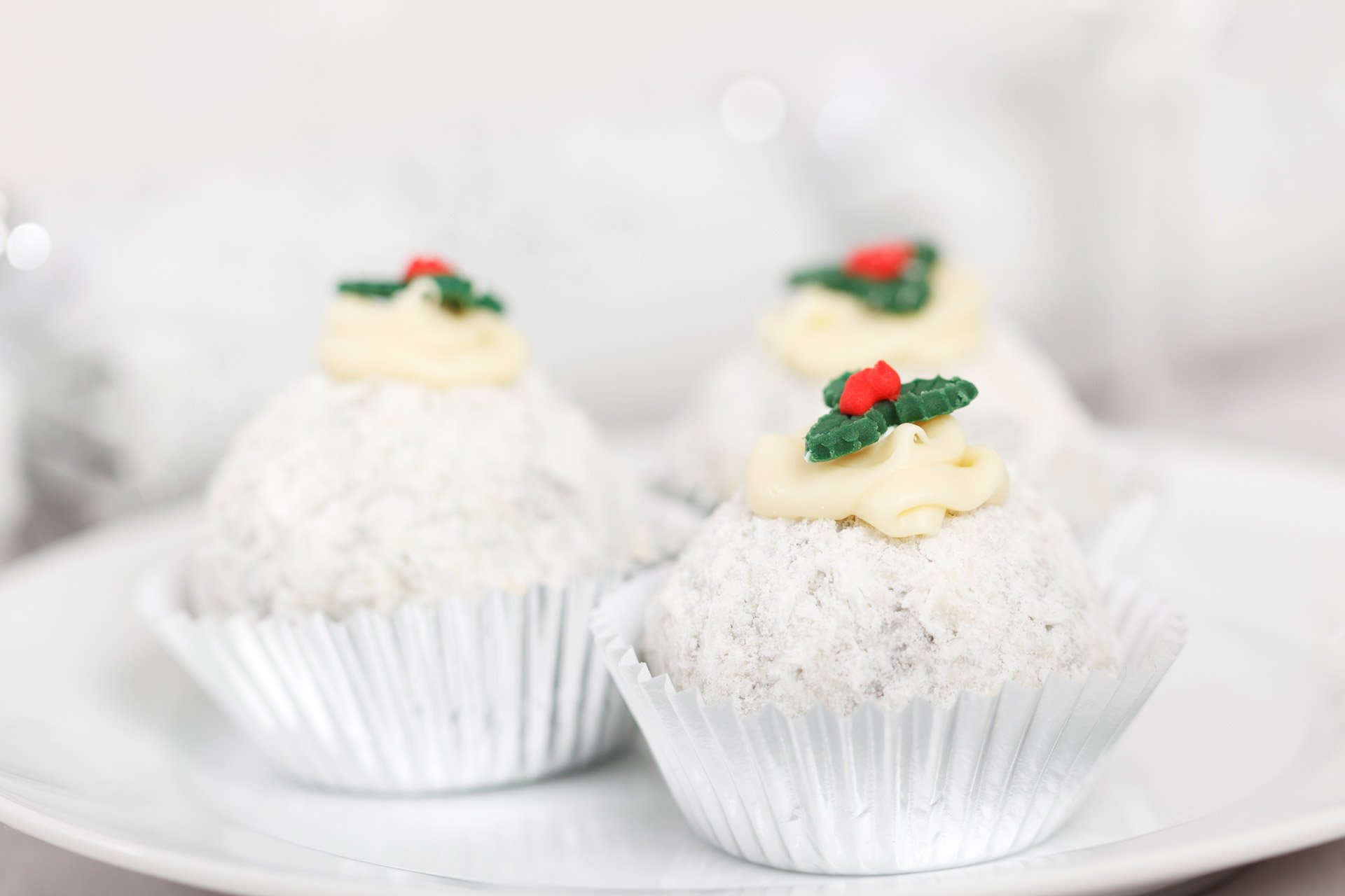 round Christmas dessert with coconut and a holly on the top