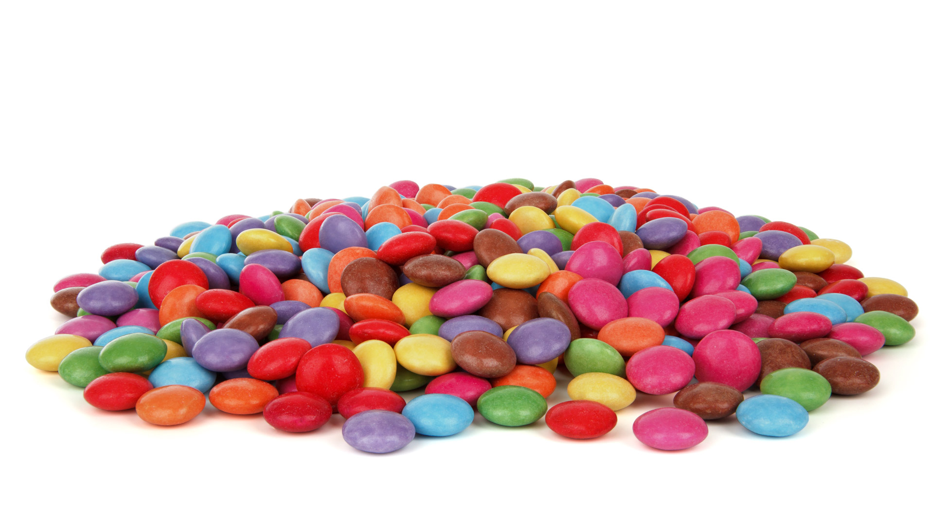 a pile of colorful sugar coated chocolate buttons isolated on white background