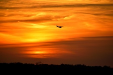 Airplane Flying At Sunset