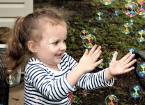 Little Girl Playing With Bubbles