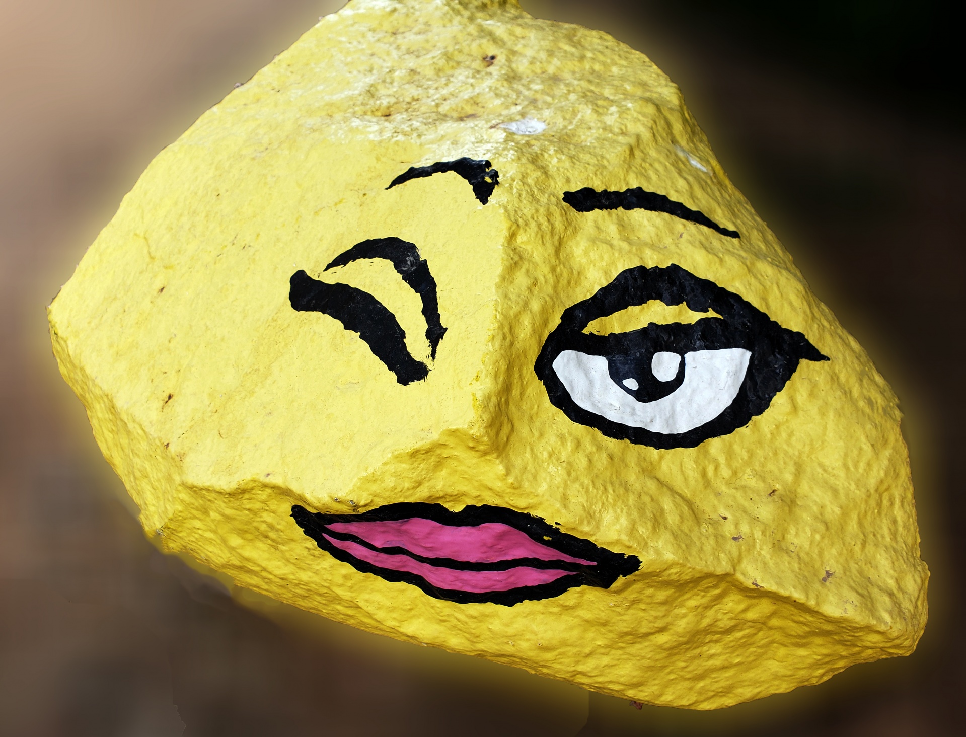cute lady face winking painted on a rock