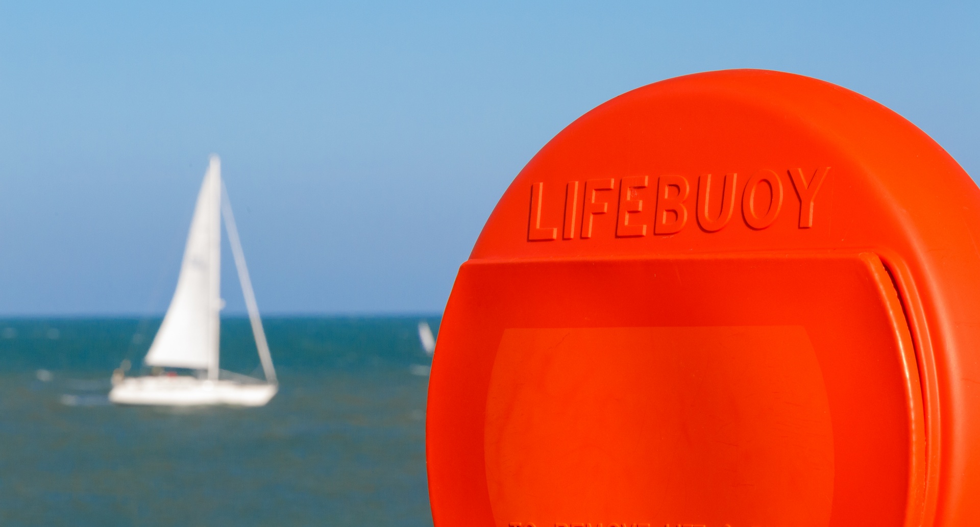 Orange lifebuoy on a shore