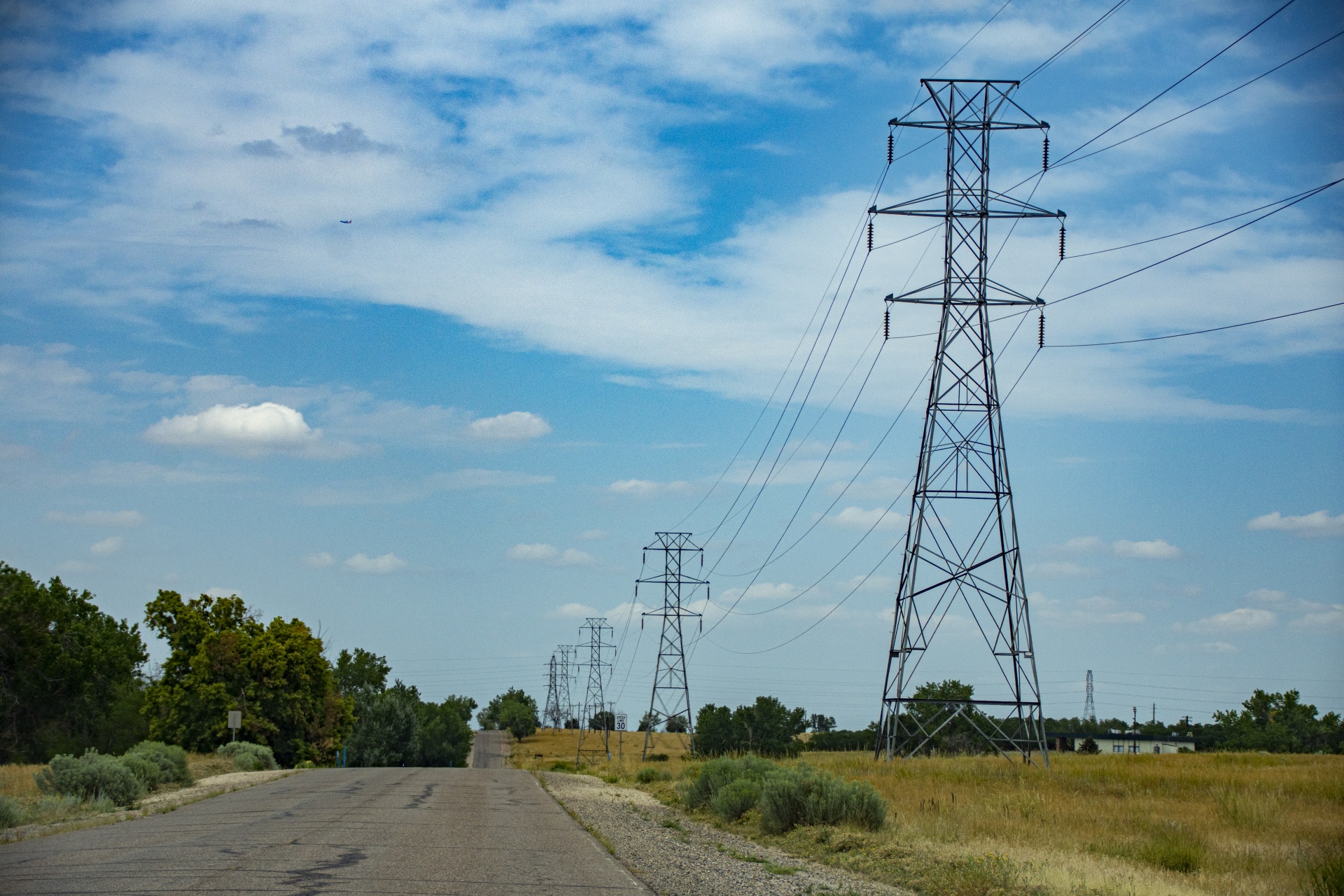 flat highway through the Colorado with high power utility lines along the road
