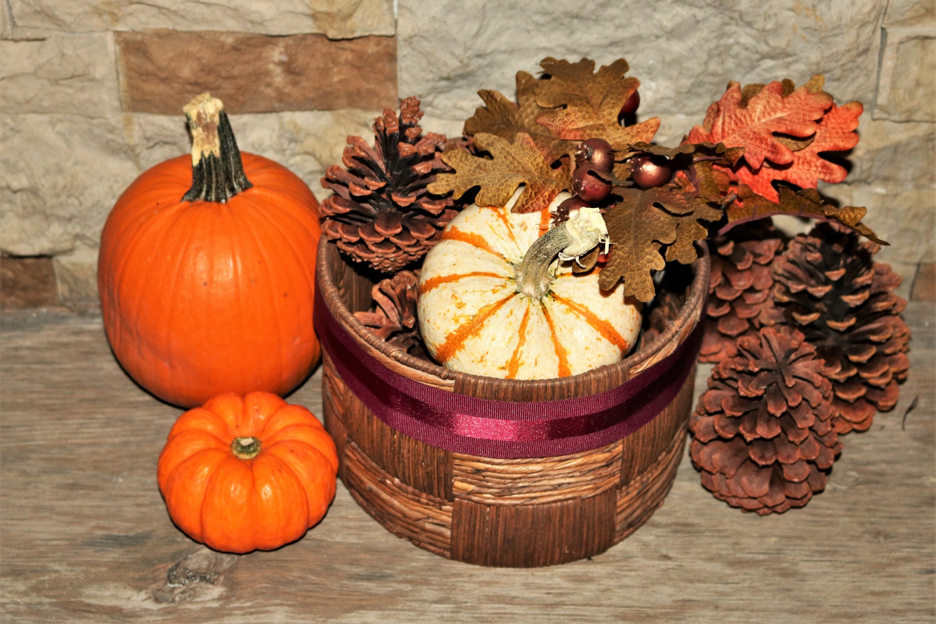 Pumpkins And Pine Cones On Wood