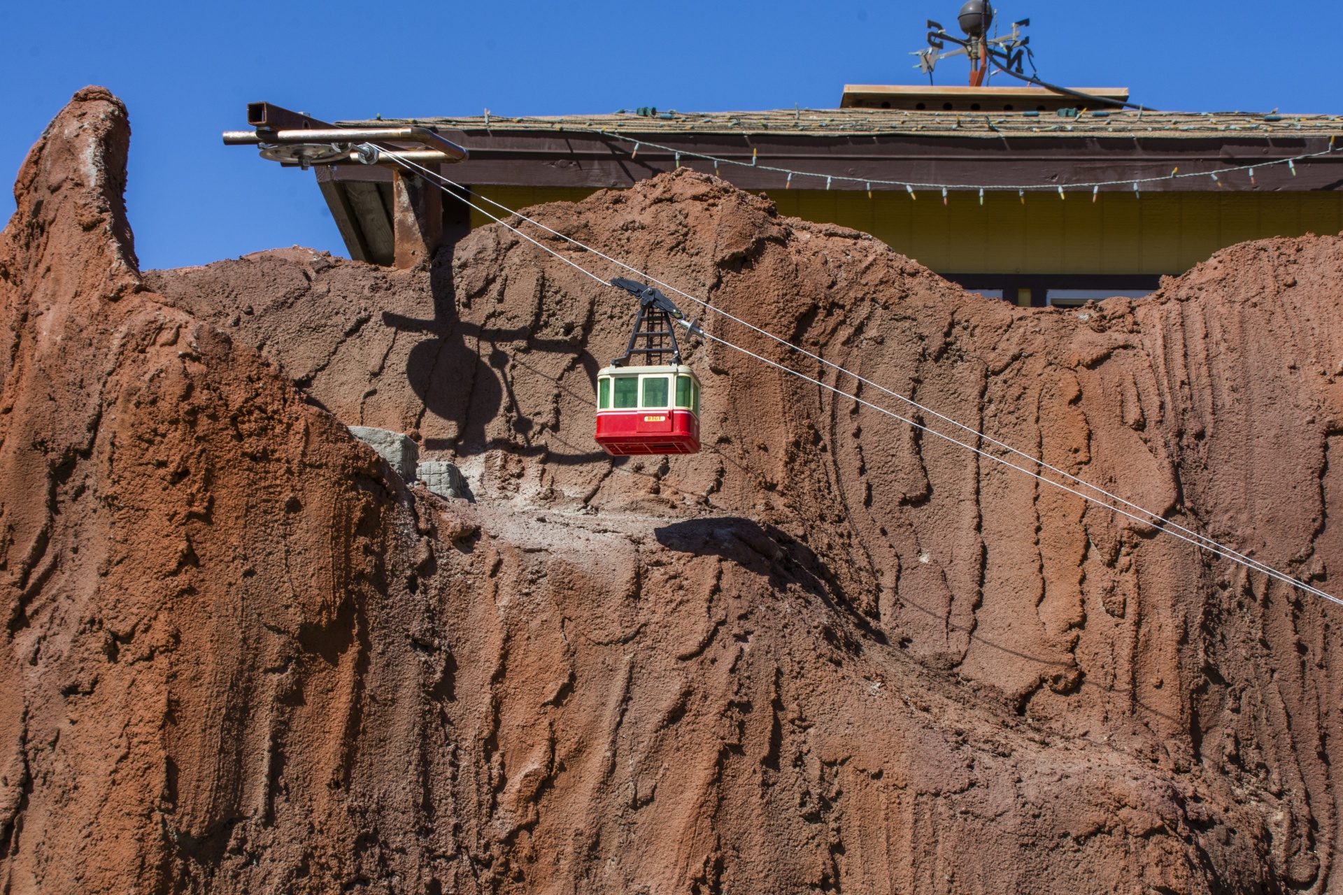 tram climbing up a red-rock mountain in a miniature train exhibit