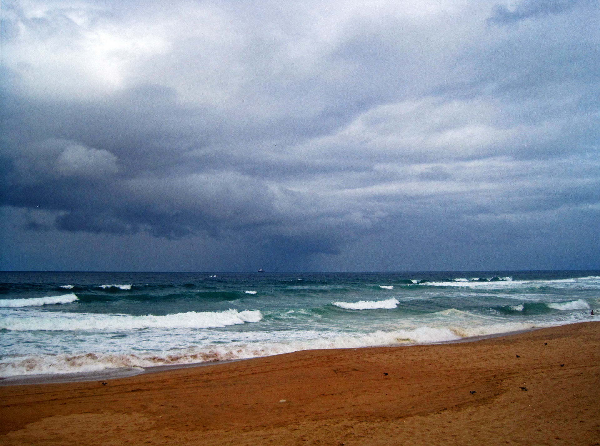 view of beach and sea under cloudy sky