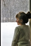 Girl Looking At Snow Through Window