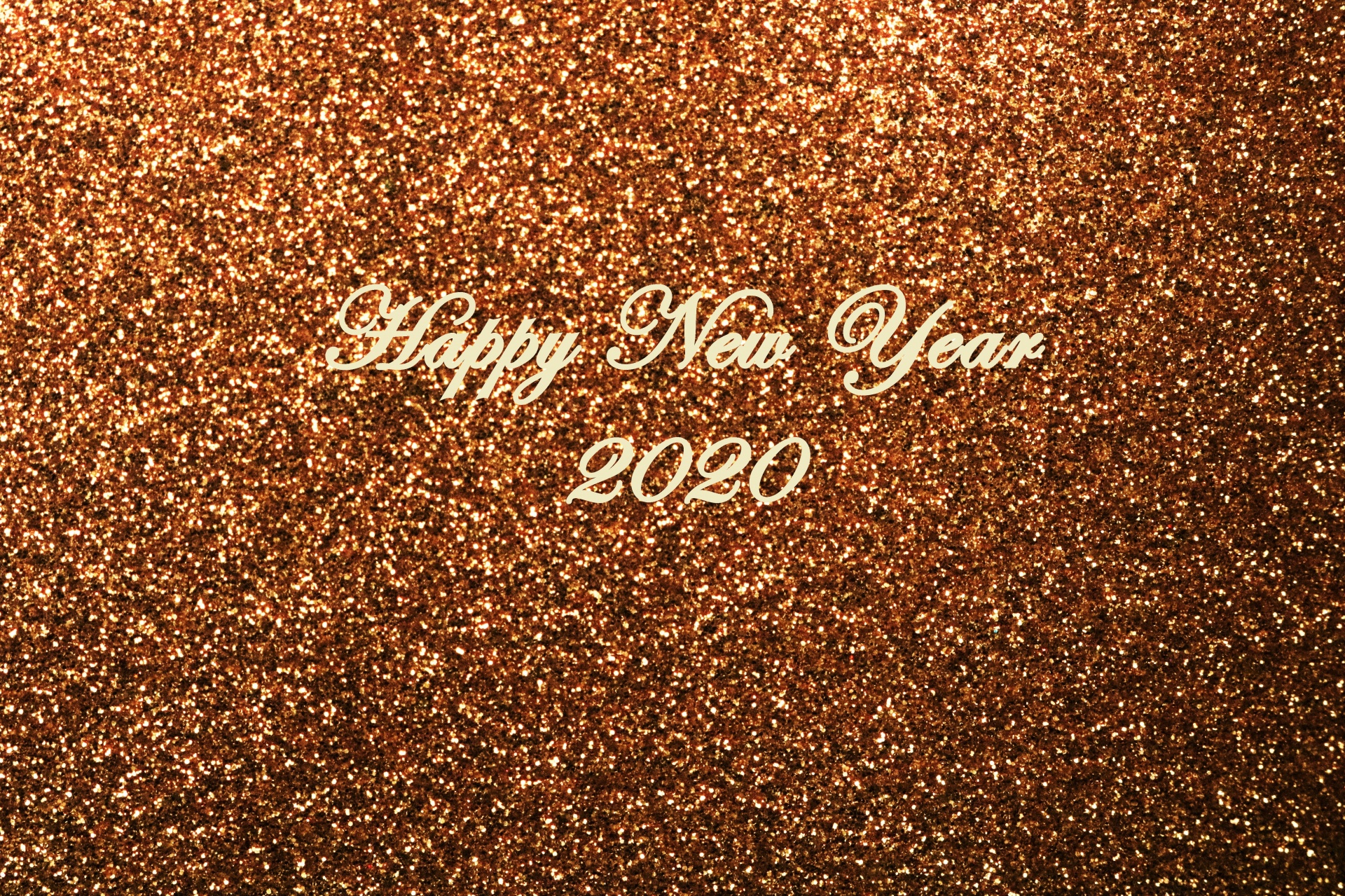 Sparkling gold glitter background with the text, Happy New Year 2020.