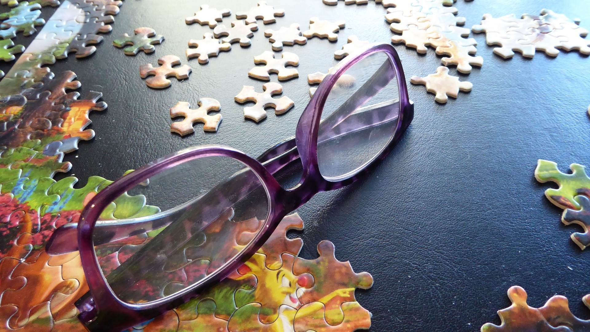 Jigsaw puzzle and a pair of eyeglasses