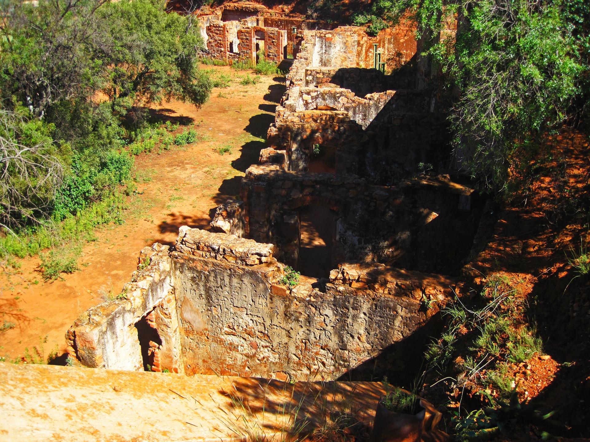 aerial view of inner structure of fort in ruin with green trees