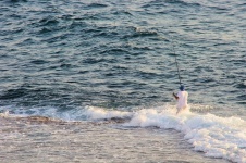 Fisherman Standing In Sea Surf