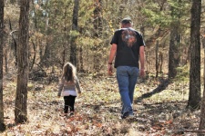 Man And Child Walking In Woods