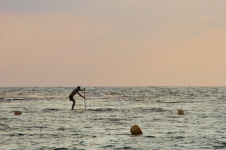 Rowing A Stand Up Paddle At Sunset