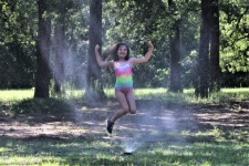 Young Girl Playing In Sprinkler