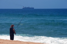Fisherman On A Beach Fishing