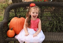 Happy Little Girl With Pumpkins
