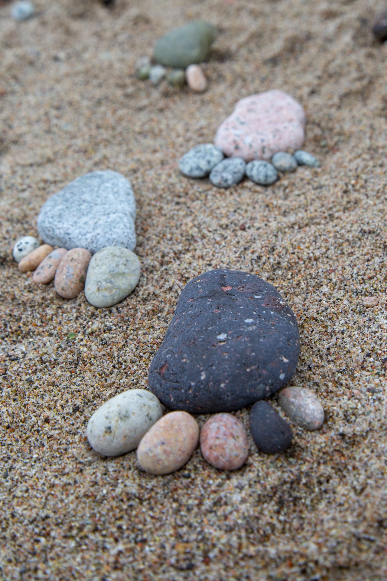 A footprint shape made of with pebble stones on sea sand background