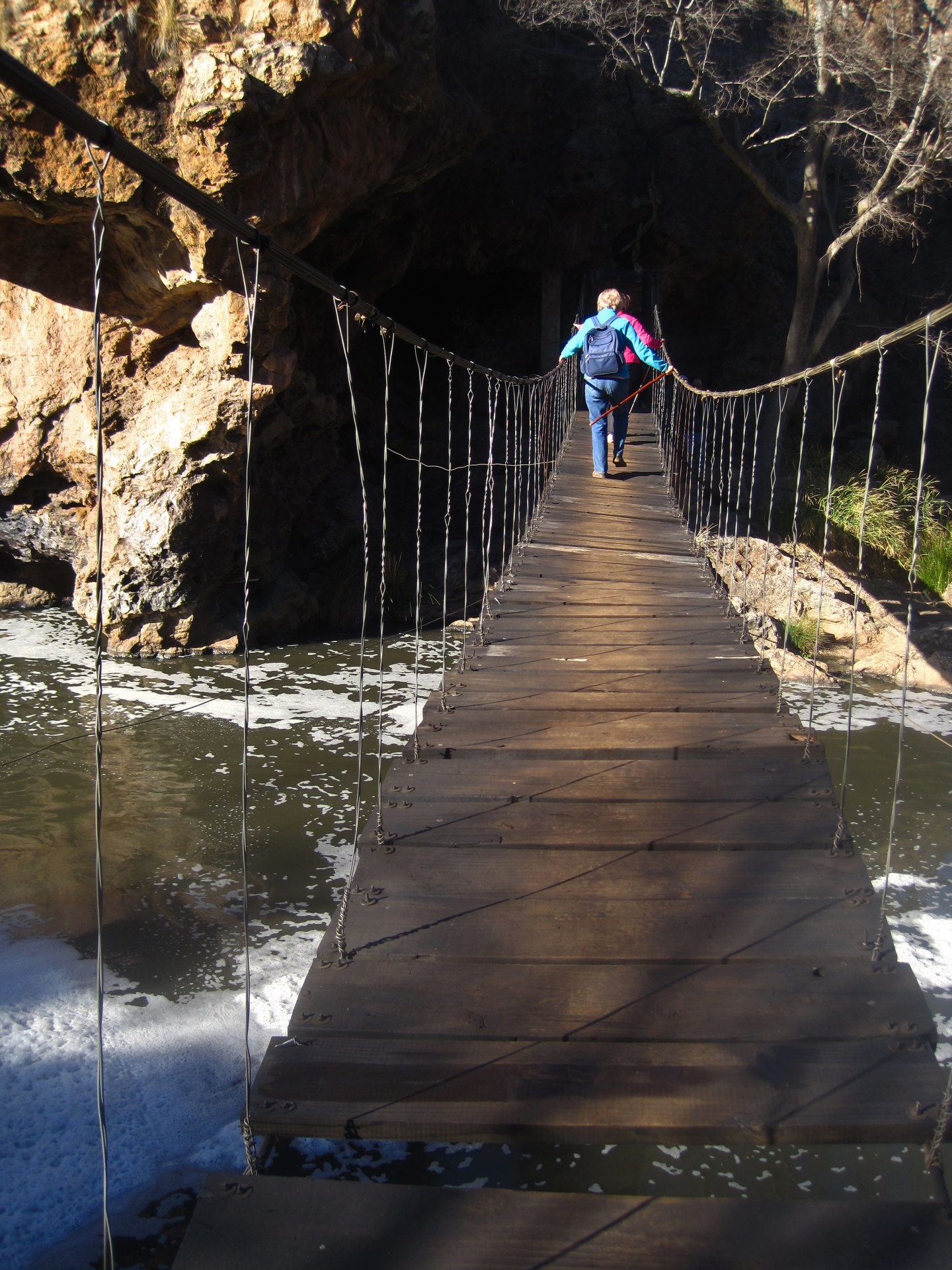 Hiker On A Low Suspension Bridge