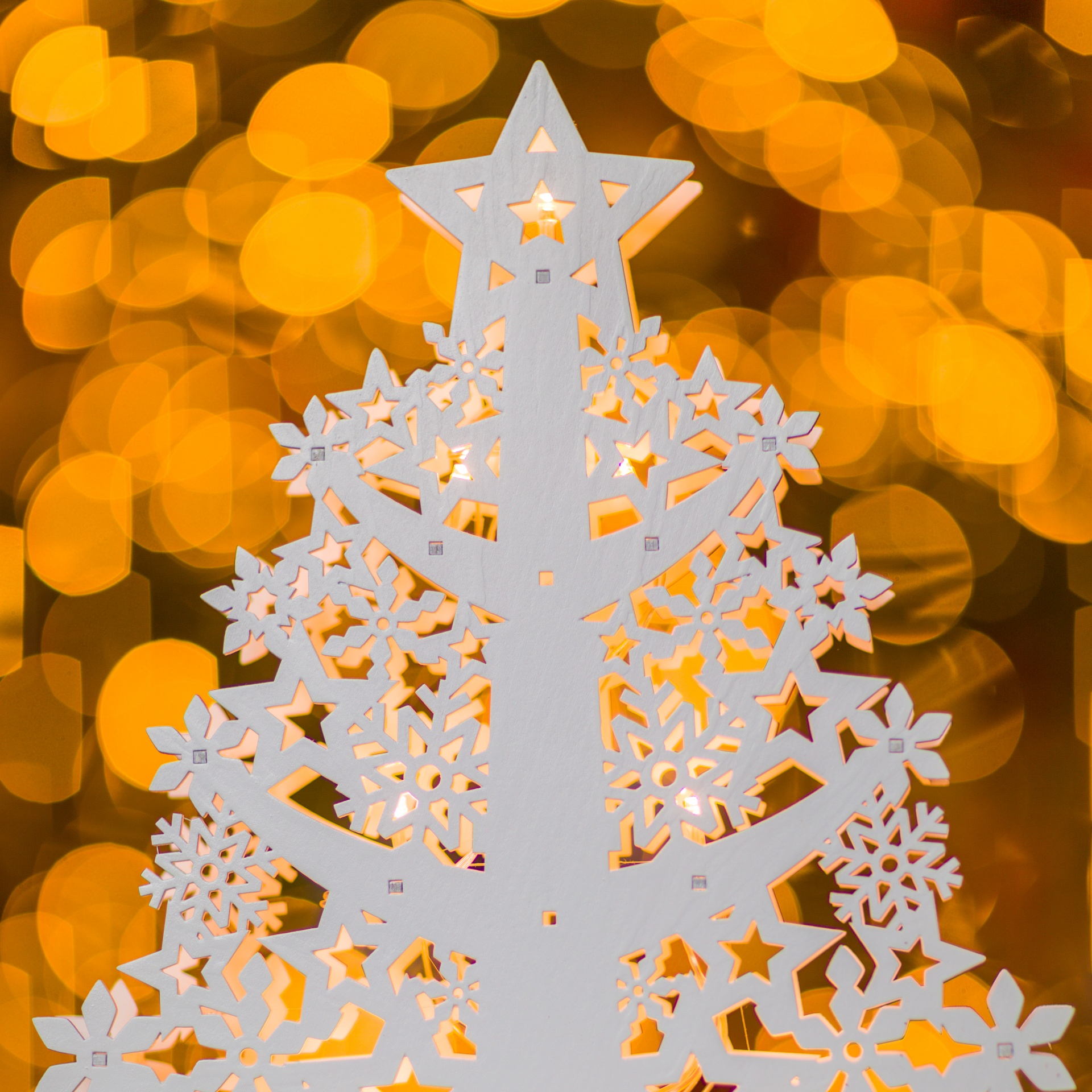 White Christmas tree decoration with yellow bokeh lights in the background