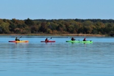 Family Kayaking On Lake In Fall