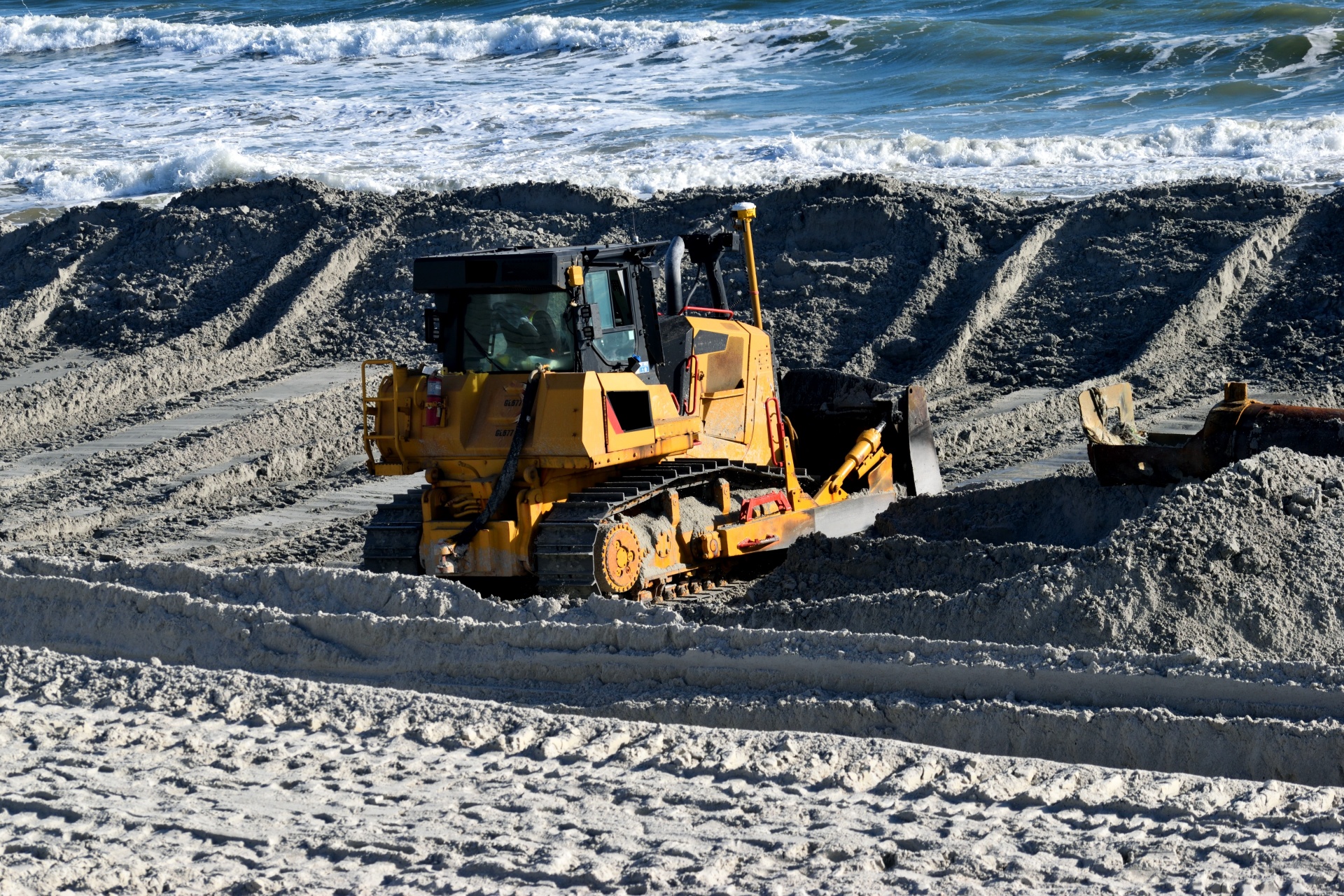 Bulldozer working at the beach dredging to fight beach erosion Florida, USA