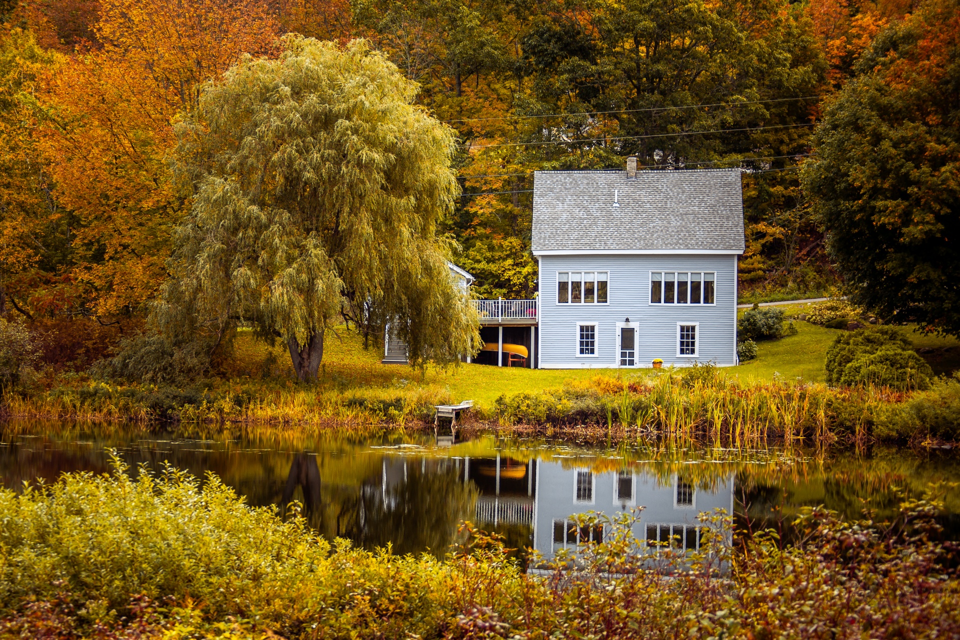 Wooden house reflection in water in fall