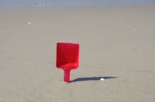 Red Plastic Spade Stuck In Sand