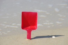 Sea Tide With Red Spade In Sand