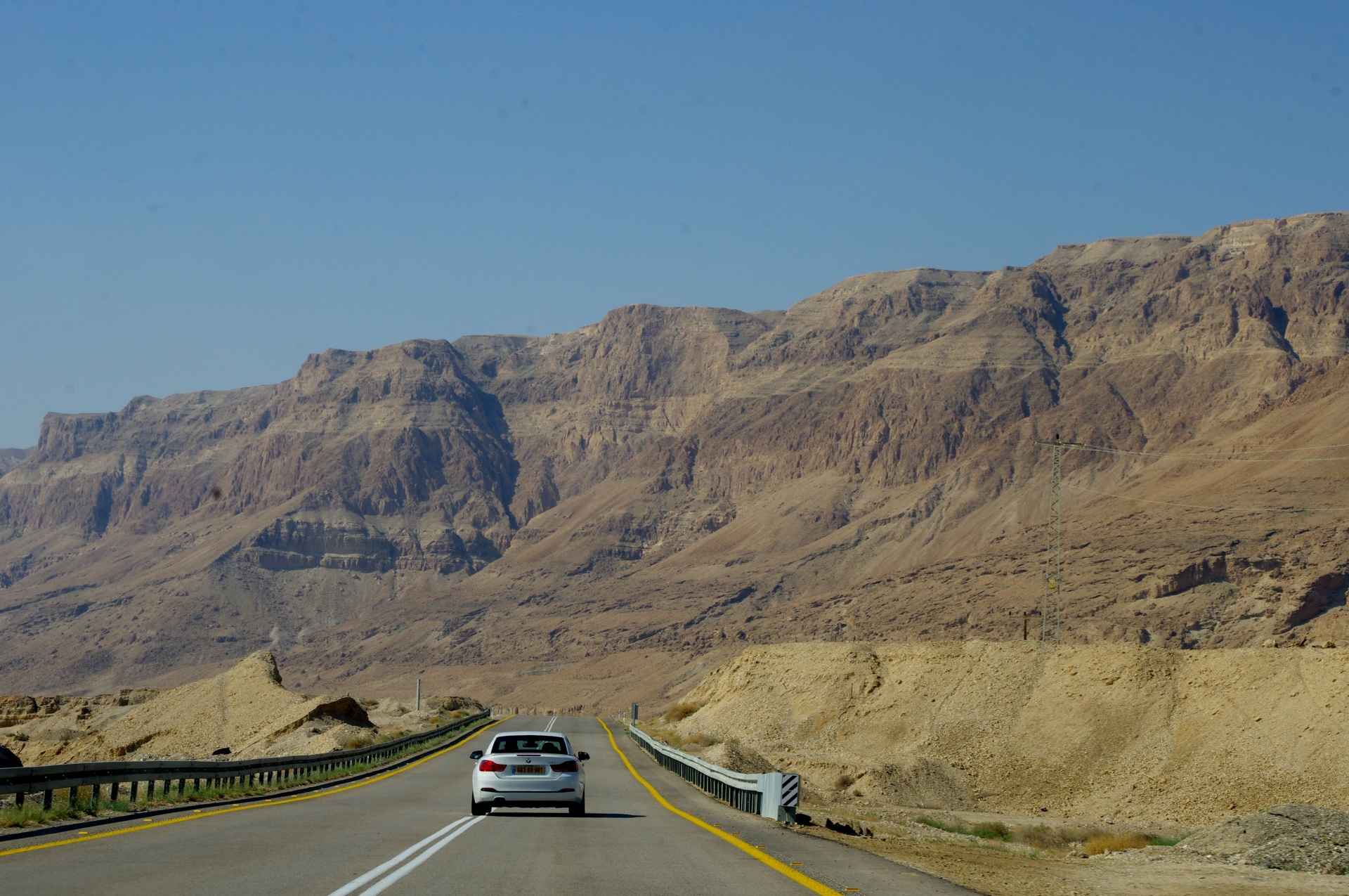 Car on open road along mountain range in Israel