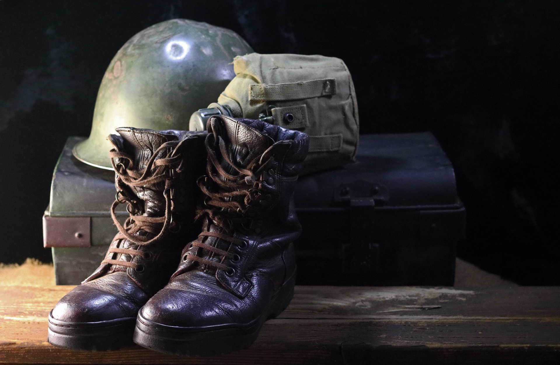 combat boots, helmet and water bottle with a metal trunk