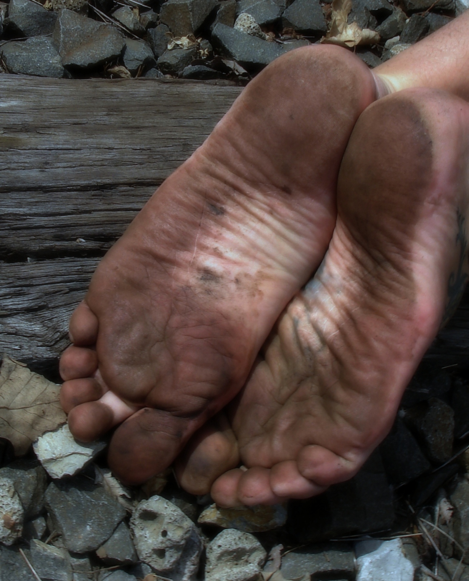 barefoot guy shows his dirty feet