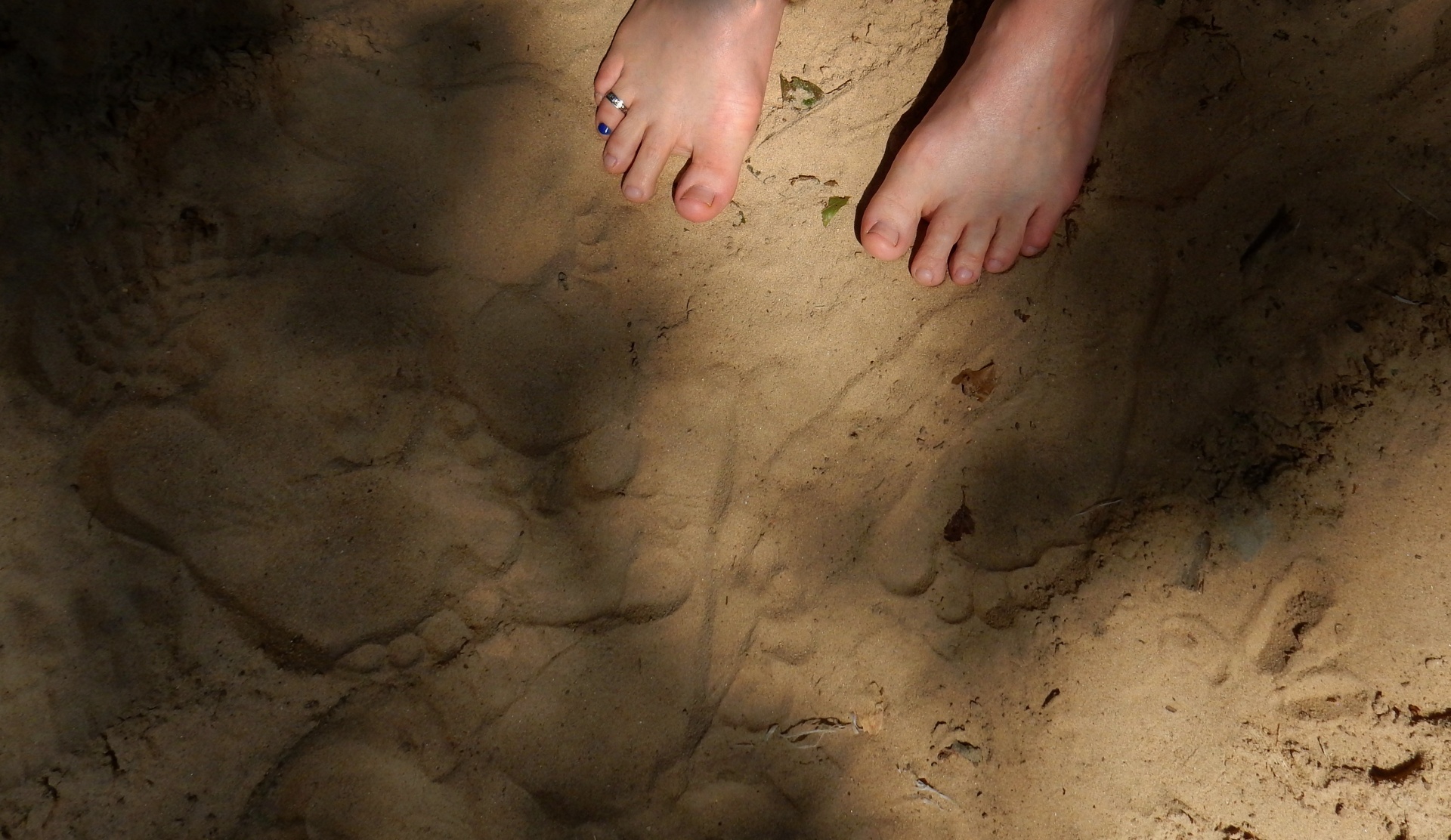 barefoot male with his toe painted blue wearing a toe ring