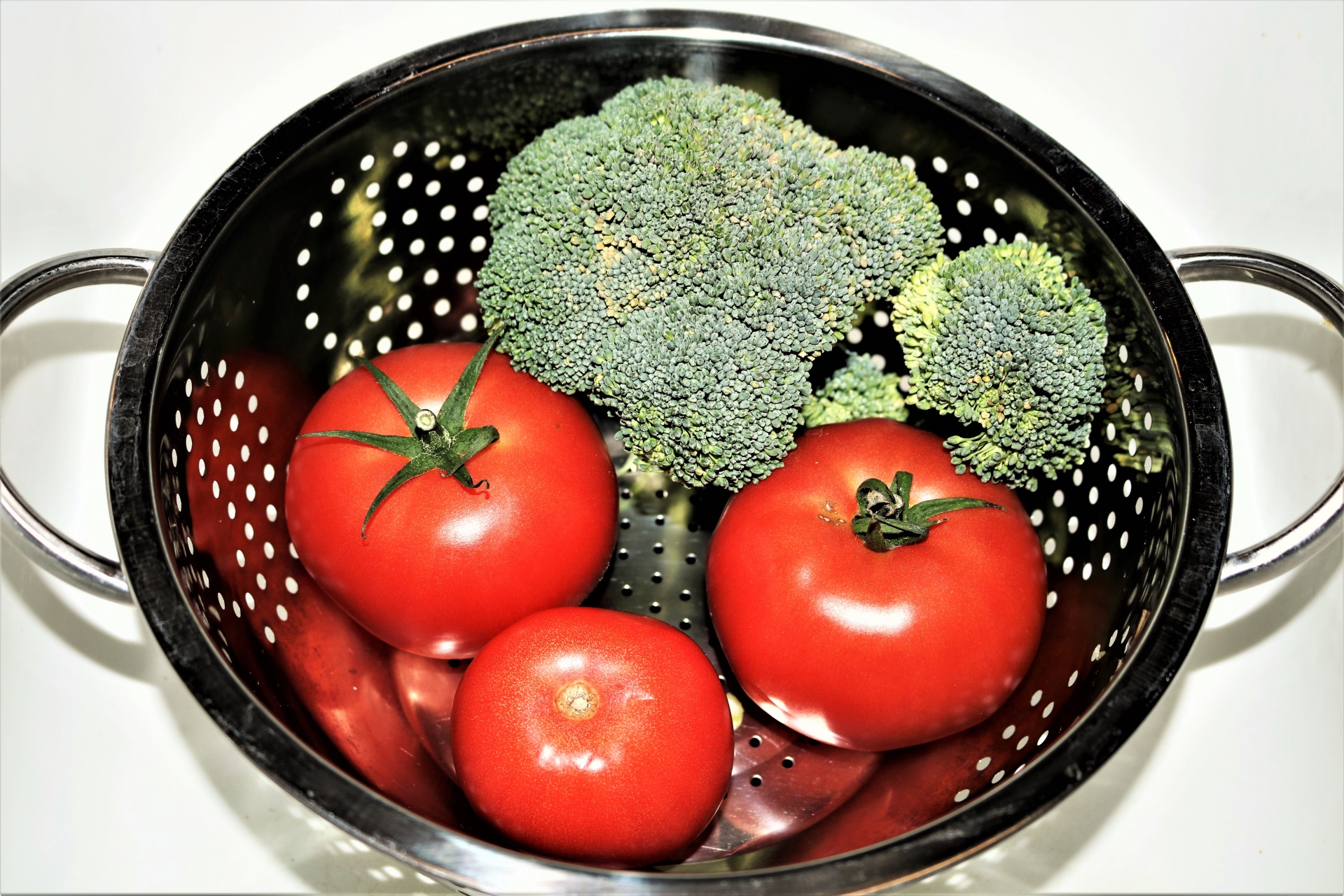 Tomatoes And Broccoli In Colander